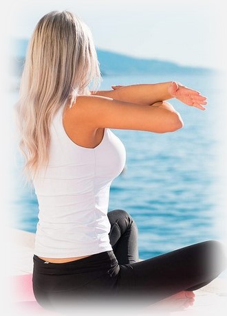 Woman sitting in yoga position on the pier
