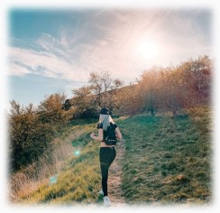 Woman on trail hiking towards rising sun